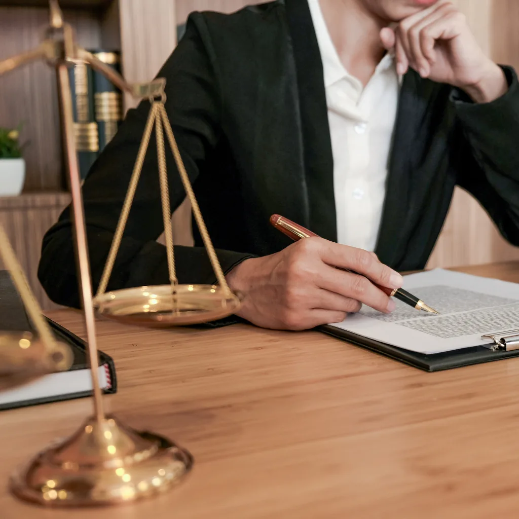 Attorney reviewing a legal document beside scales