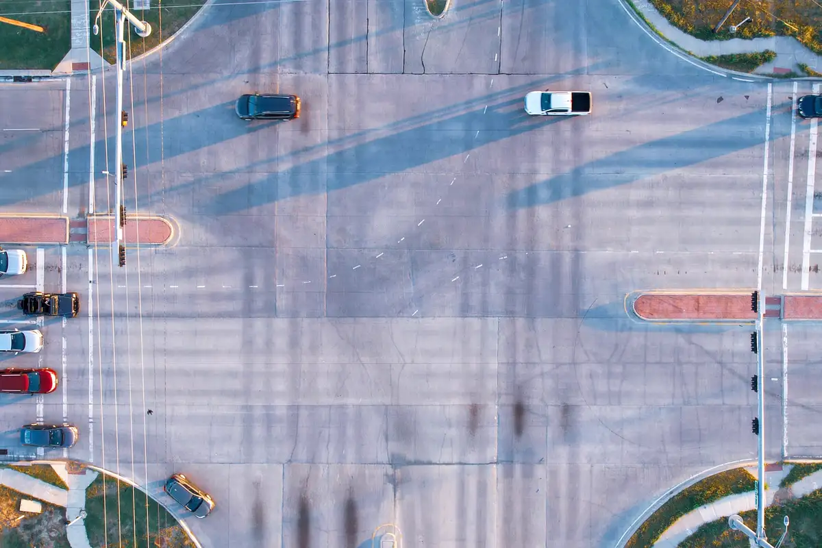 Overhead view of vehicles moving through a large signal-controlled intersection