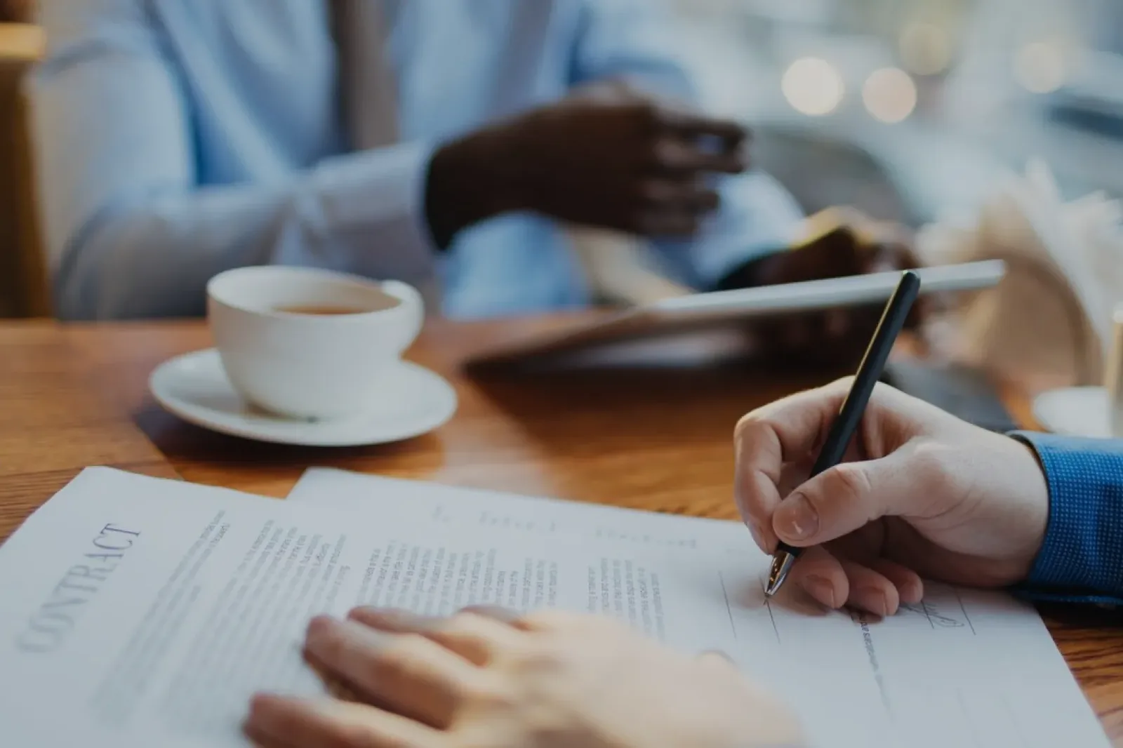 Two people signing an agreement at a table