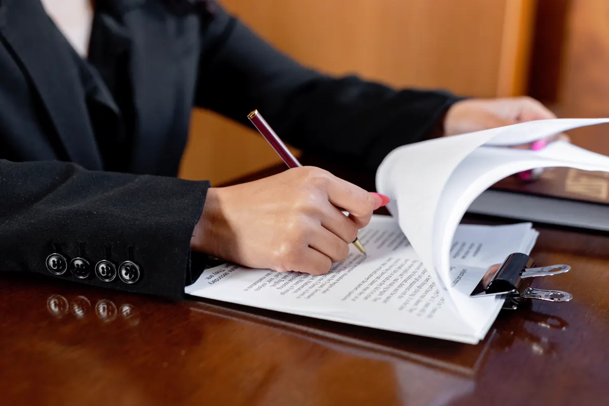 Close-up of a person reviewing a printed document with a pen